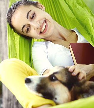 Health woman in hammock with dog