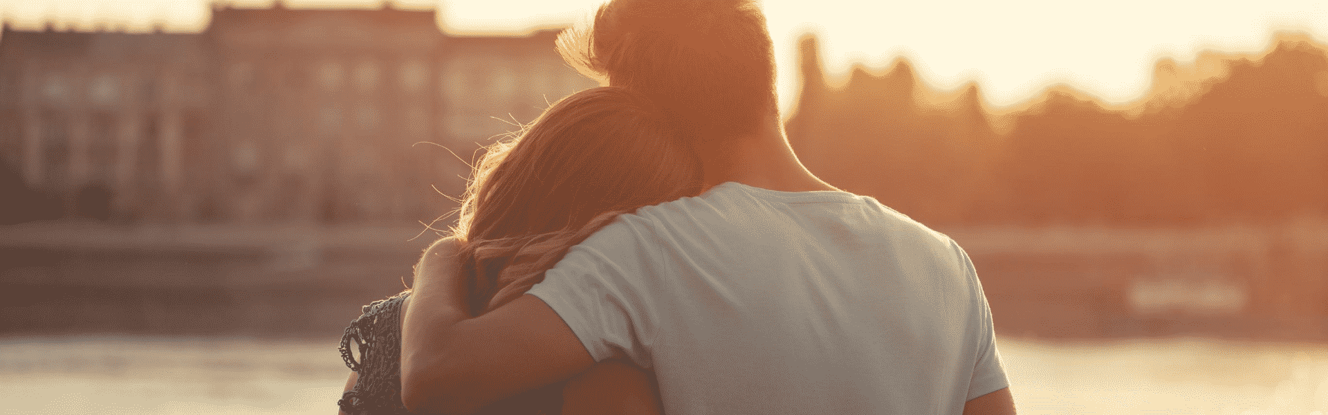 Couple hugging looking into the sunset