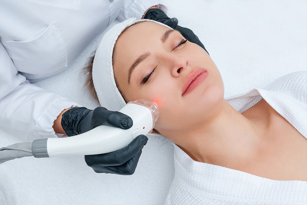 Woman laying down getting procedure to face